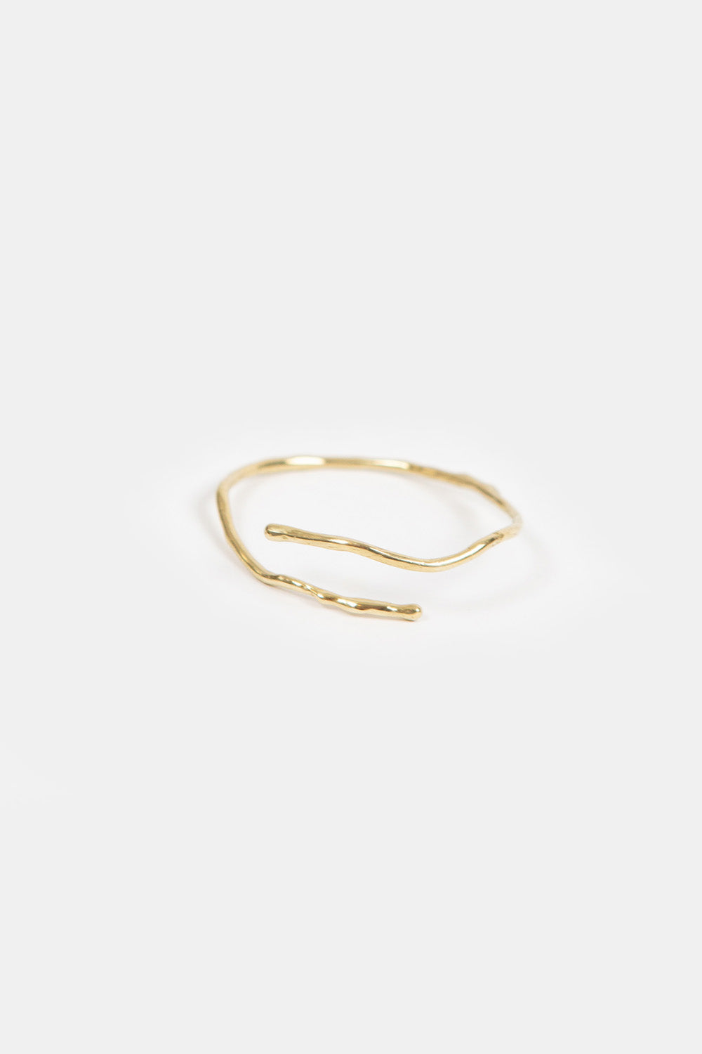 Brass open bracelet on a white background.